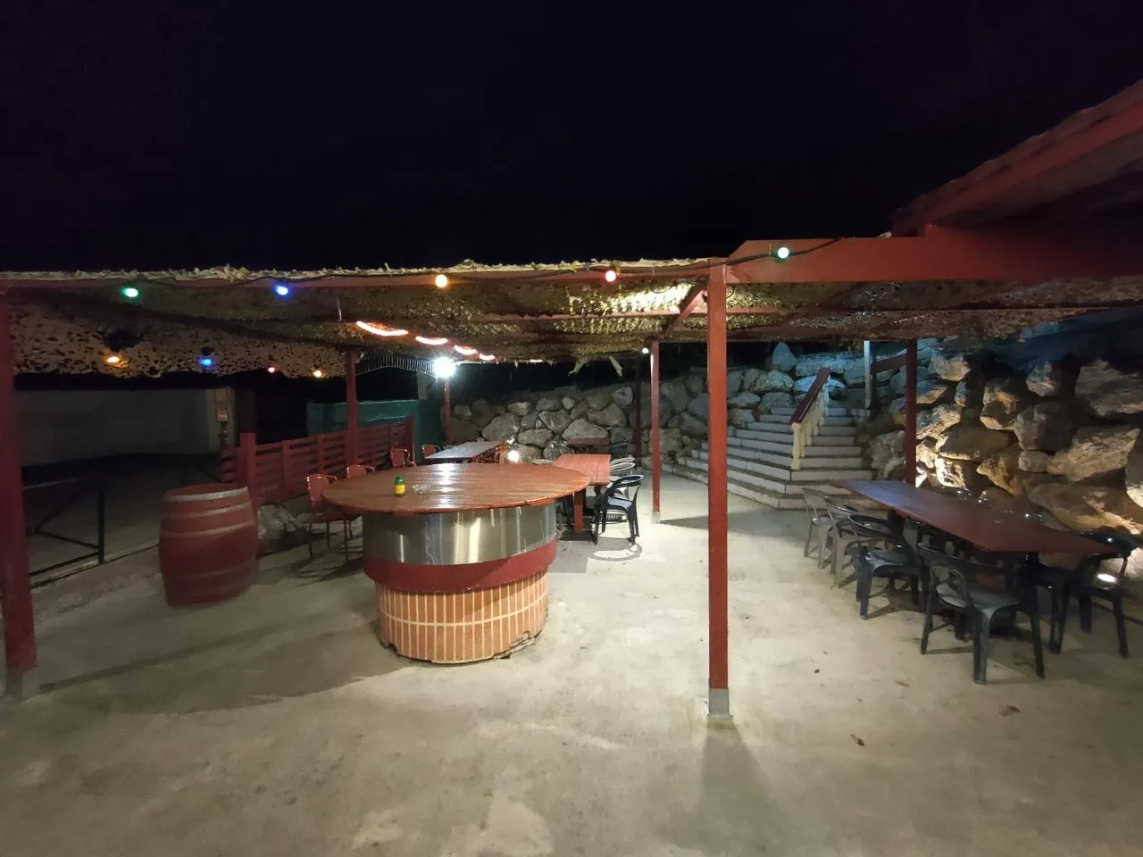 Terrasse couverte de Mont Relais Gaillard éclairée le soir par des guirlandes colorées.
